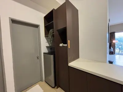 a kitchen with a counter and a refrigerator at JS Comfortable Stay Golden Hills Pasar Malam 3Bedrooms 2Bathrooms in Brinchang