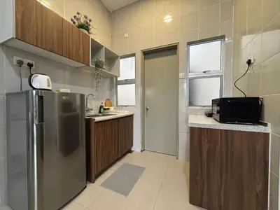 a kitchen with a stainless steel refrigerator and wooden cabinets at JS Comfortable Stay Golden Hills Pasar Malam Studio in Brinchang