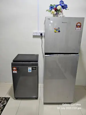 a refrigerator and a trash can with a vase of flowers at Homestay ZAF sitiawan in Sitiawan