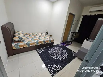 a bedroom with a bed and two rugs on the floor at Homestay ZAF sitiawan in Sitiawan