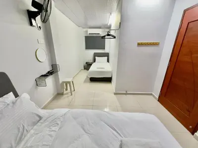 a bedroom with a white bed and a bathroom at Spacious 2 Storey Homestay Tanjung Bungah 25Pax by 3C in Tanjung Bungah