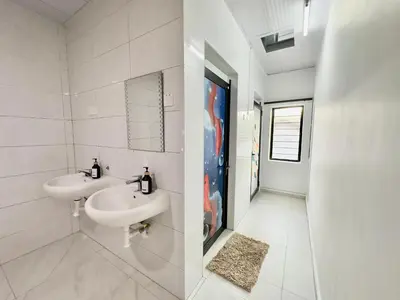 a white bathroom with two sinks and a mirror at Spacious 2 Storey Homestay Tanjung Bungah 25Pax by 3C in Tanjung Bungah