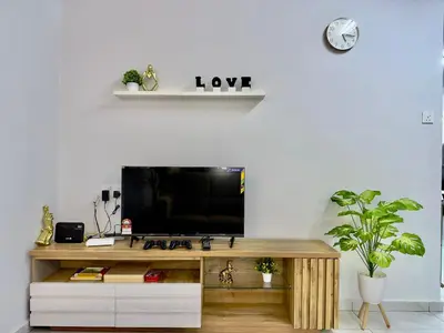 a tv sitting on top of a wooden table at Spacious 2 Storey Homestay Tanjung Bungah 25Pax by 3C in Tanjung Bungah