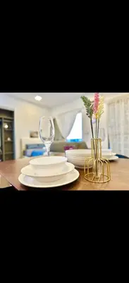 a table with plates and a wine glass on it at Cybersquare Vertex Tower in Gua Sai