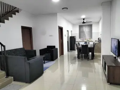 a living room with a couch and a table with chairs at Yatie Homestay in Gua Musang