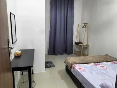 a bedroom with a bed and a desk in a room at Yatie Homestay in Gua Musang