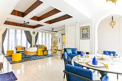 a living room with blue and yellow chairs and a table at Bertam Wellness Spa & Villas - A Member of Small Luxury Hotels of the World in Kepala Batas