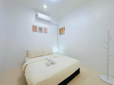 a white bedroom with a bed with a stuffed animal on it at BM Alma AutoCity Aeonjusco in Bukit Mertajam