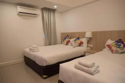 two beds in a hotel room with towels on them at Mornington Hotel Waterfront Lumut in Lumut