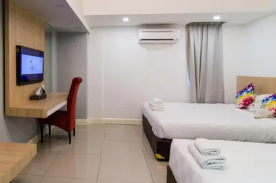 a hotel room with two beds and a desk at Mornington Hotel Waterfront Lumut in Lumut