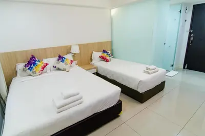 a hotel room with two beds and a mirror at Mornington Hotel Waterfront Lumut in Lumut