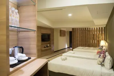 a hotel room with two beds and a television at Mornington Hotel Waterfront Lumut in Lumut