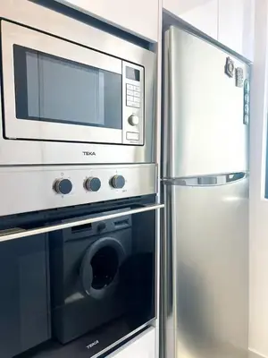 a microwave and a refrigerator in a kitchen at Beacon #2BR FamilyStay #22Georgetown in George Town