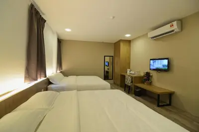 a hotel room with two beds and a television at De Parkview Hotel in Ipoh