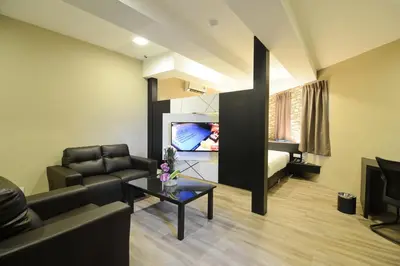 a living room with a couch and a tv at De Parkview Hotel in Ipoh