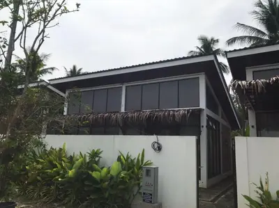 a house with a black roof and a white fence at As Sufi Village in Kampung Sungai Air Tawar