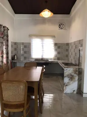 a kitchen with a wooden table and a dining room at As Sufi Village in Kampung Sungai Air Tawar