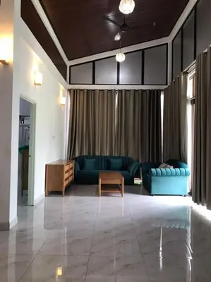 a living room with a blue couch and a table at As Sufi Village in Kampung Sungai Air Tawar