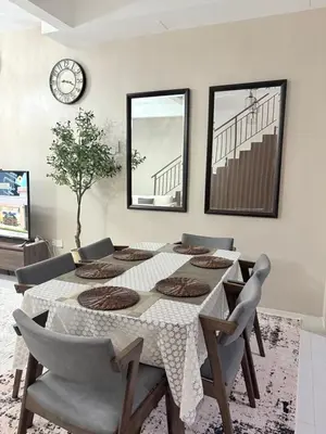 a dining room with a table and chairs and a clock at Homestay Taman Scientex Kota Tinggi in Gua Sai