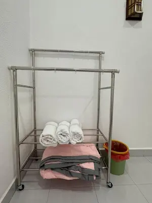 a towel rack with towels on it in a room at Happy Guest House Taman Cowin Nibong Tebal \u5f00\u5fc3\u6c11\u5bbfTaman Cowin\u9ad8\u6e0a\u533a in Nibung Tebal