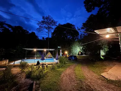 a night view of a yard with a tent at Camping River View in Gua Sai