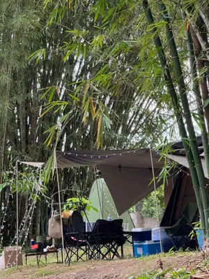a tent and two chairs under a tree at Camping River View in Gua Sai