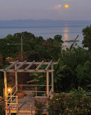 a view of the ocean from a house at night at VELAMUNDi INN Batu Ferringhi in Batu Ferringhi