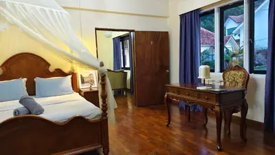 a bedroom with a bed and a desk and a desk at VELAMUNDi INN Batu Ferringhi in Batu Ferringhi