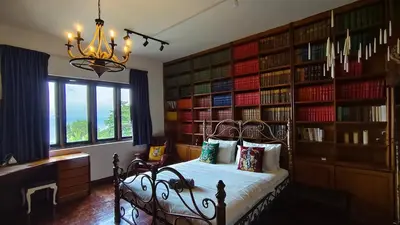 a bedroom with a bed in a room with book shelves at VELAMUNDi INN Batu Ferringhi in Batu Ferringhi