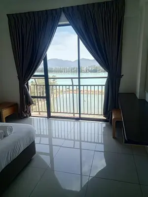 a bedroom with a large window with a view of the water at Marina sunset view in Lumut