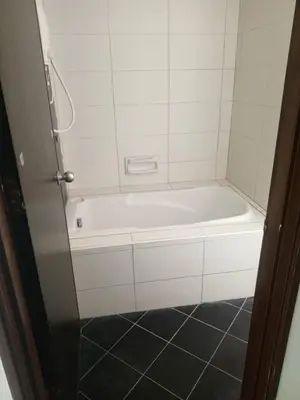 a white bath tub in a bathroom with a tile floor at Marina sunset view in Lumut