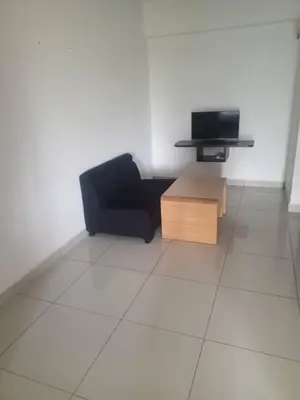 a living room with a black couch and a coffee table at Marina sunset view in Lumut