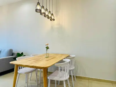 a dining room table with white chairs and a vase on it at CozyStay Rooftop Sky Pool Sea &Bridge View Luxury 9pax in Bayan Lepas