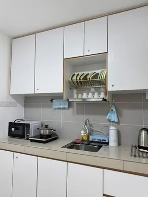 a kitchen with white cabinets and a sink and a microwave at Manhattan Condominium Ipoh' Rachel in Ipoh