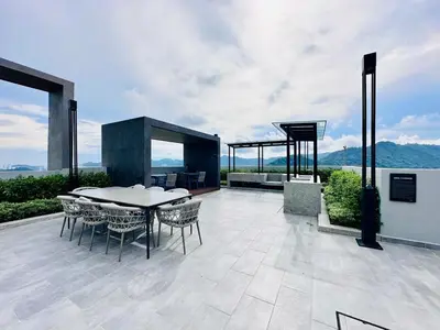 a patio with a table and chairs on a building at New LuxurySuite Rooftop Pool Stunning View airport 9pax in Bayan Lepas