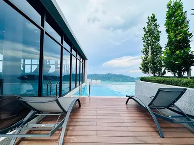 two chairs sitting on a deck next to a swimming pool at New LuxurySuite Rooftop Pool Stunning View airport 9pax in Bayan Lepas