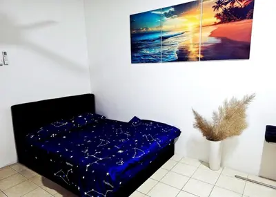 a bed in a room with a painting on the wall at Blue House Kampar 3BR Family Suite-Kids Playroom Near UTAR in Kampar