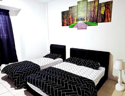 two beds in a bedroom with a painting on the wall at Blue House Kampar 3BR Family Suite-Kids Playroom Near UTAR in Kampar