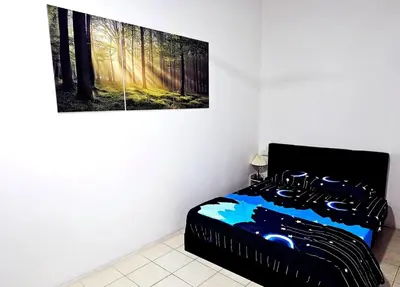 a bedroom with a bed with a picture on the wall at Blue House Kampar 3BR Family Suite-Kids Playroom Near UTAR in Kampar