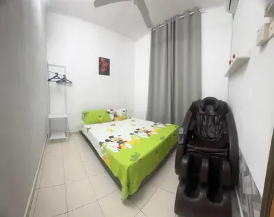 a childs bedroom with a green bed and a chair at Homestay Dmickey in Sungai Petani