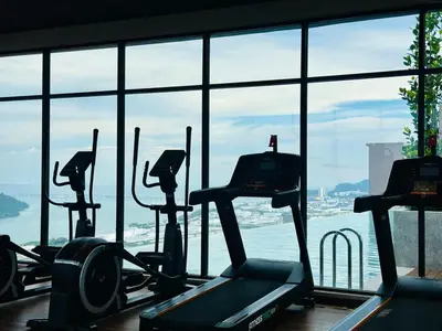 a gym with several treadmills in front of a window at Luxe Seaview Rooftop Pool Airport bayan lepas in Bayan Lepas