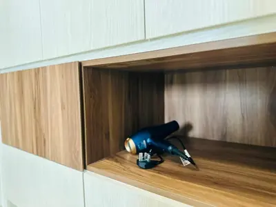 a blue blow dryer in a wooden cabinet at Luxe Seaview Rooftop Pool Airport bayan lepas in Bayan Lepas