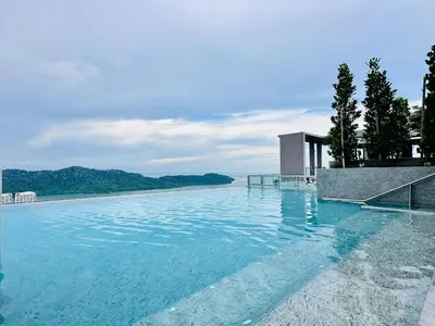 a large swimming pool with blue water and trees at Sea Bridge View Sky Pool Cozy 3BR Retreat airport 9pax in Bayan Lepas