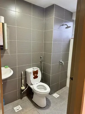a bathroom with a toilet with a monkey on the seat at AYAAN Nova PingPong House Free Parking in Tanah Rata