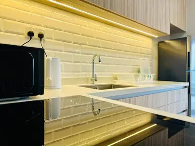a kitchen with a sink and a microwave at Explore Penang Stay Style w Sky pool Sea airport 9pax in Bayan Lepas