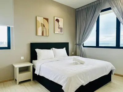 a bedroom with a large bed and two windows at Sky Pool Luxury Sea View Near Penang Airport 9pax in Bayan Lepas