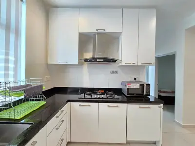 a kitchen with white cabinets and a stove top oven at Shamrock Beach Villas - Batu Ferringhi in Tanjung Bungah