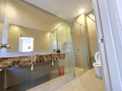 a bathroom with a shower and a sink and a toilet at Shamrock Beach Villas - Batu Ferringhi in Tanjung Bungah