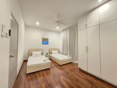 a living room with two beds and a couch at Shamrock Beach Villas - Batu Ferringhi in Tanjung Bungah