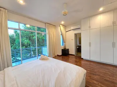 a bedroom with a white bed and a large window at Shamrock Beach Villas - Batu Ferringhi in Tanjung Bungah